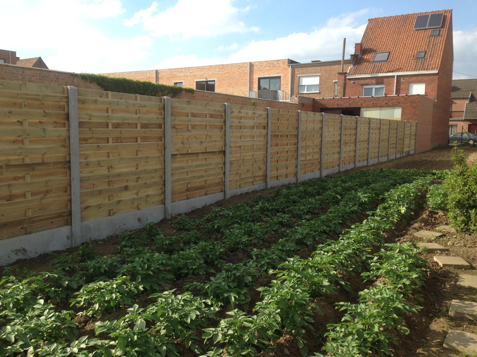 Houten panelen met betonpalen en boordstenen