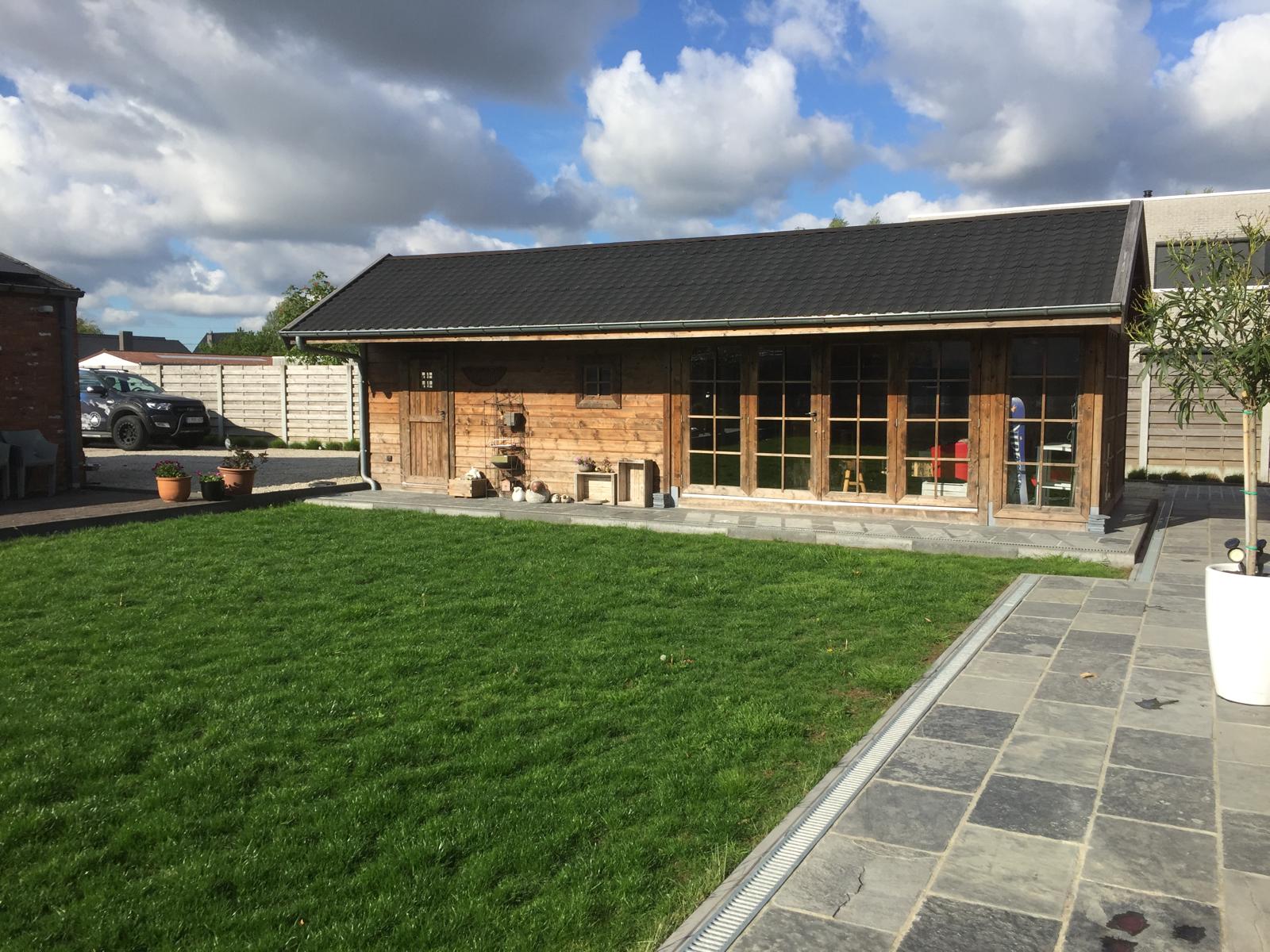 Terras in natuursteen voor een houten tuinhuis